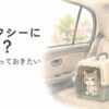 普通のタクシーの後部座席で、キャリーに入ったシニア猫と飼い主が一緒に移動するイメージ