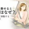 車内のキャリーで鳴くシニア猫と運転する女性飼い主